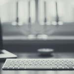 Laptop and keyboard facing windowsill