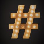 Gold hashtag light fitting on black background